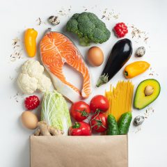 Supermarket. Paper bag full of healthy food on a white background. Top view. Flat lay. Copy space.